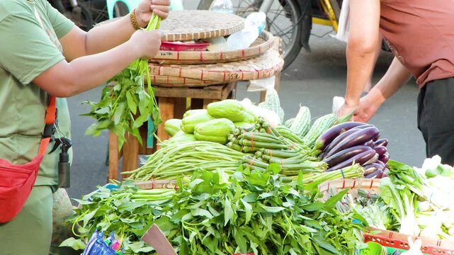 Filipino Street Market Vendor Arranging Fresh Vegetables in Manila