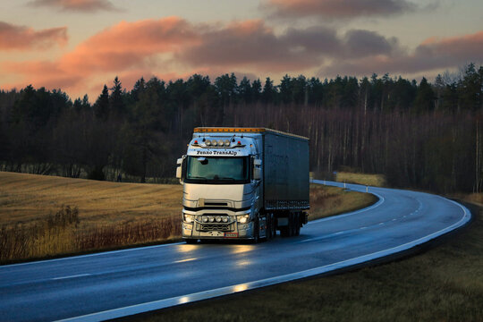 Silver Renault T truck semi trailer on rural highway at sunset time. Copy space. 