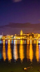 Obraz premium A serene cityscape at night with a body of water