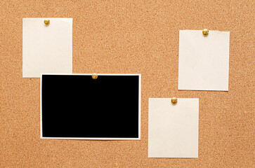 Fototapeta premium Blank paper notes and an empty photo are pinned to a cork board. The concept of detective investigation or a webinar.