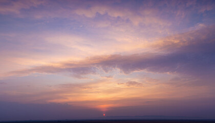 Obraz premium Beautiful sunset sky with fluffy clouds displaying various shades of orange, purple, and blue, vast and expansive natural background