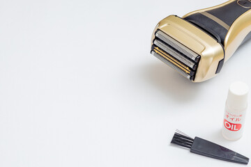 金色の電気シェーバーとオイルとブラシ