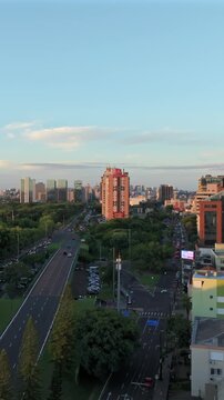 Vertical ascent over Porto Alegre shows Borges de Medeiros Ave and Praia de Belas Ave with skyline at sunset.