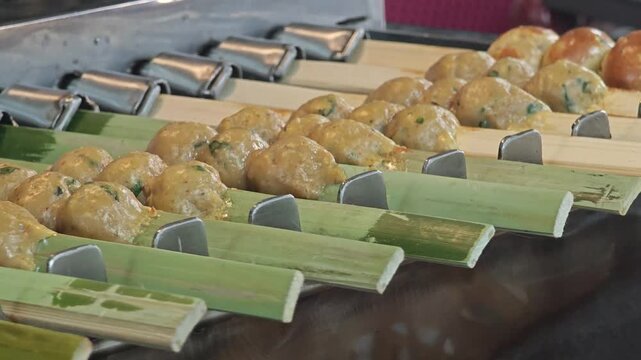 Grilled curry fish paste balls on a skewer.