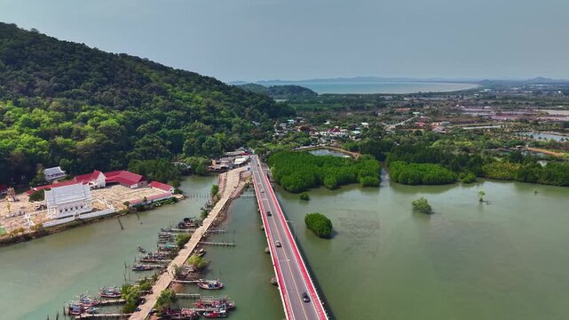 Cinematic aerial drone video over Taksin Bridge in Chanthaburi province, Thailand. Filmed in mid-afternoon at approximately 70&ndash;90 meters, revealing dynamic bridge angles, traffic route perspective, an