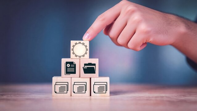 Hand stacking wooden blocks with document and gear icons,information management and business process organization system concept