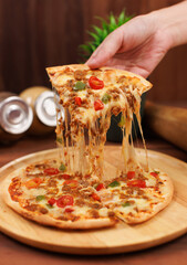 Small homemade frozen pizza toppings minced meat spicy chili sauce stretching melty cheese golden...