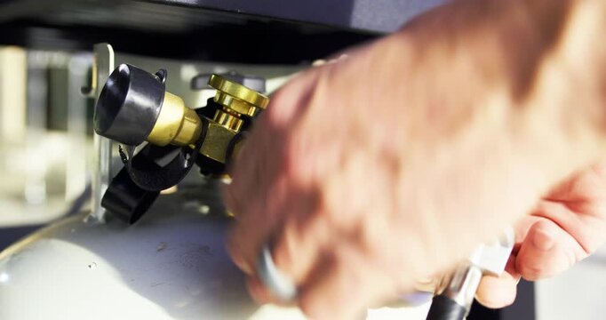 Gas hose being attached to propane tank - closeup shot