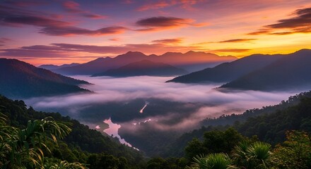 Obraz premium Sunrise Over Misty Mountain Valley with River and Tropical Rainforest