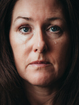 Close up of woman crying with tears running down her face.