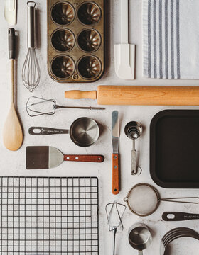 Many baking tools arranged in linear way on light background.