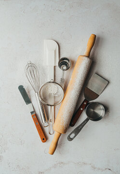 Overhead of flour dusted baking tools on light background.