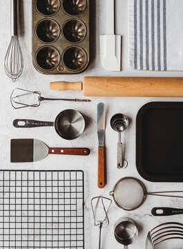 Many baking tools arranged in linear way on light background.