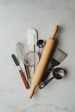 Overhead view of variety of baking tools on light background.