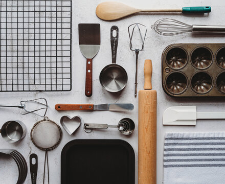 Many baking tools arranged in linear way on light background.