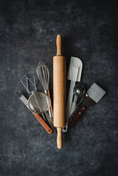 Overhead view of baking tools grouped together on black background.