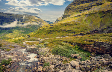 Obraz premium Autumn mountain landscape in Norway. Winding road in the mountains. Road 63 to Geiranger. View from Upper Blaafjeld Bridge