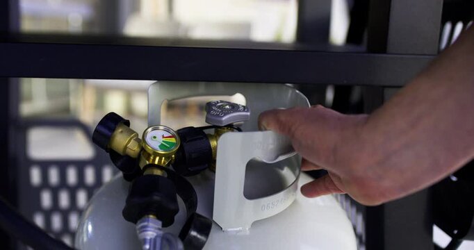 Closeup shot on man's hand opening and closing valve on propane tank