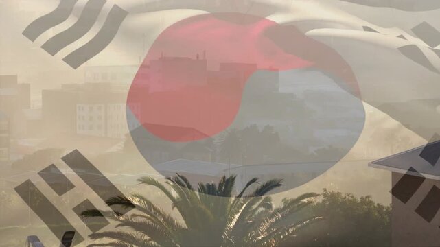 Breeze lifting semi-transparent South Korean flag, rippling and revealing hazy skyline, palm tree