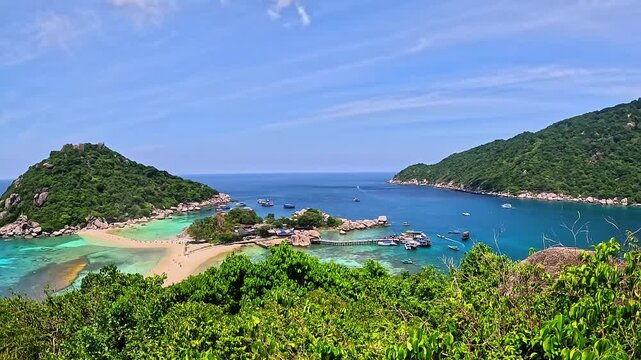 The panoramic video smoothly pans across lush Koh Nang Yuan island (Thailand), capturing crystal-clear turquoise waters, golden sandy beach, scattered boats, and dense greenery