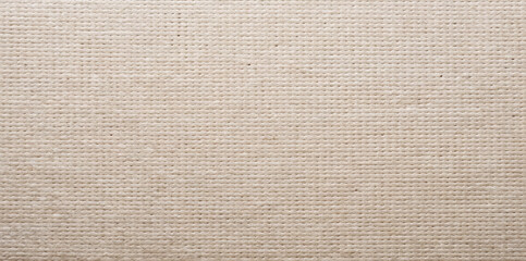 Fototapeta premium A light fabric texture is displayed. The fabric has a woven pattern that is soft and uniform. The scene is well lit, showing details of the weave clearly