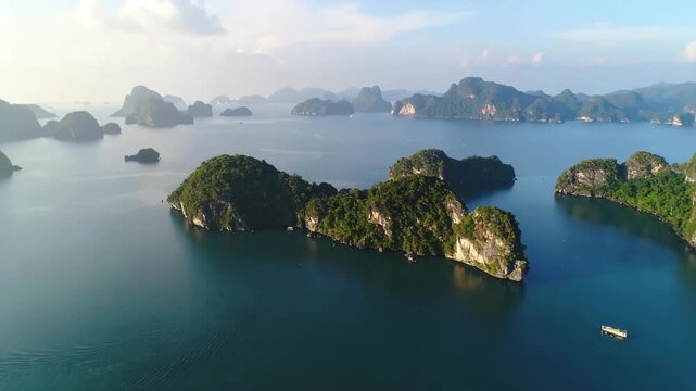 Aerial view of verdant limestone karsts rising from calm blue ocean waters
