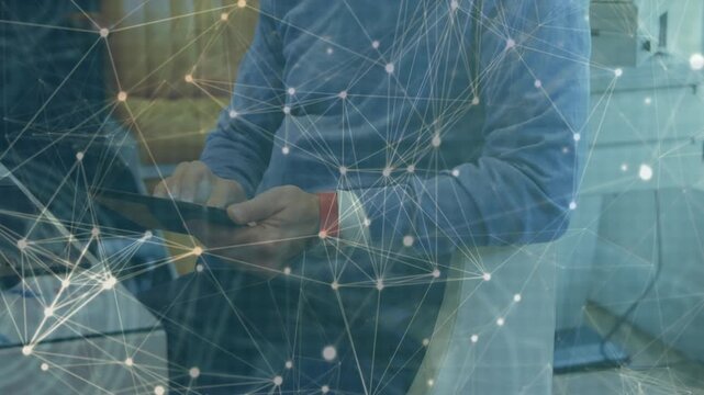 Male worker tapping tablet and initiating network overlay expanding over subject for analytics