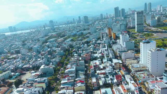 Aerial view of Da Nang city Vietnam with dense urban buildings and modern skyline under blue sky. Da Nang shows fast growing Asian city, real estate development, population density and urban life.