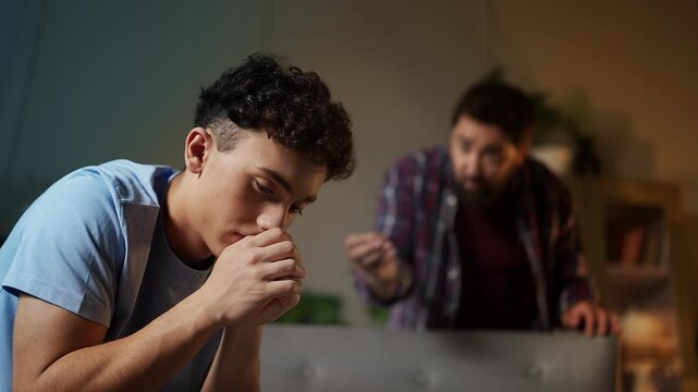 Displeased father scolding his adolescent son for bad behavior, family crisis