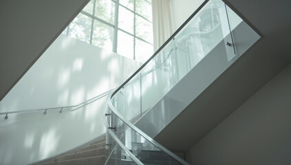 Obraz premium Modern curved glass staircase with soft natural light and shadow play