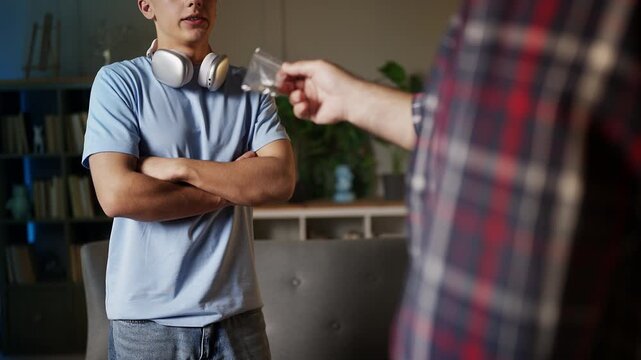 Irritated father scolding his teenage son for smoking pot, addiction risk