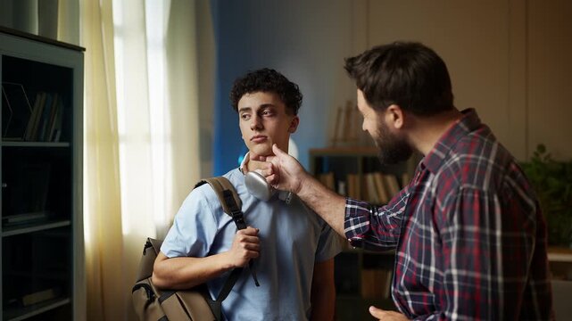Caring father looking at his teenage son�s black eye, showing support and love