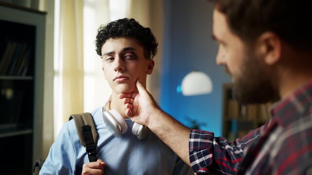 Dad comforting his teen son with a swollen eye, expressing empathy and support