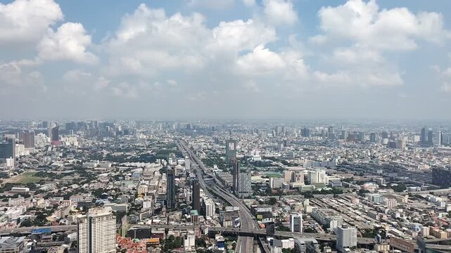 Aerial view of Bangkok city skyline with traffic and blue sky, Thailand.