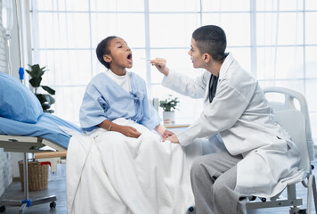 Obraz premium Little African American girl opening mouth for doctor