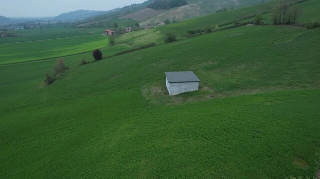 Pallastrelli farmland landscape near Lugagnano Val d Arda in Province of Piacenza Emilia Romagna showing green crop field, country road and isolated farmhouse at foothills of Apennine range