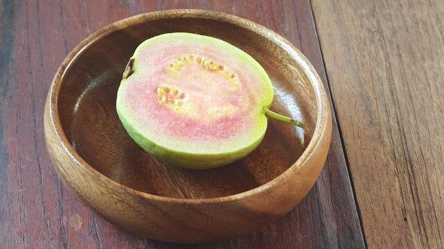 Fresh guava fruit ,cut in half showing pink fleshFresh guava fruit with slices 