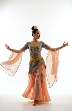 Malaysian dancer performs Tarian Zapin in ornate costume. Woman in traditional dress with gold embroidery moves gracefully. Cultural art isolated on white background.