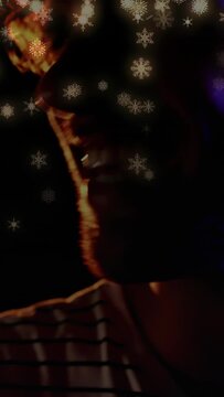Vertical video: Male singer leaning to mic, singing for music, snowflake over face, lights shifting