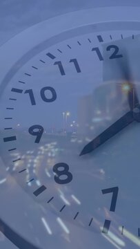 Vertical video: Clock overlay starting hands rotating clockwise, city lights shifting, showing time