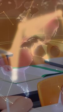 Vertical video: Students moving from reading to writing while globe fading over desks for education