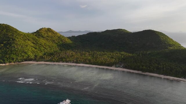 Drone aerial view of Bayang Basecamp or Calibangbangan Camp and turquoise reef along Calibangbangan Island coastline between Coron and El Nido, Palawan, Philippines.