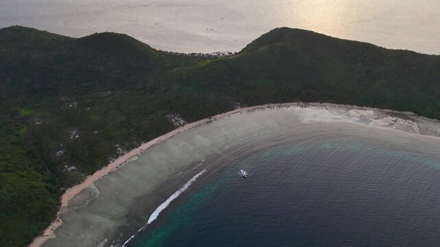 Drone aerial view of Bayang Basecamp or Calibangbangan Camp and turquoise reef along Calibangbangan Island coastline between Coron and El Nido, Palawan, Philippines.