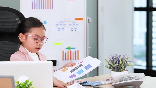 Young Asian Girl in Business Suit Reviewing Documents at Office Desk