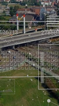 Vertical video: HUD activating, overpass receiving data overlays and grids, tracking traffic flow