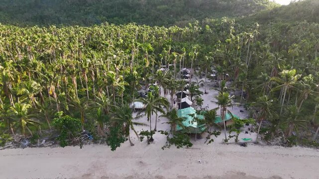 Drone aerial view of Bayang Basecamp or Calibangbangan Camp and turquoise reef along Calibangbangan Island coastline between Coron and El Nido, Palawan, Philippines.