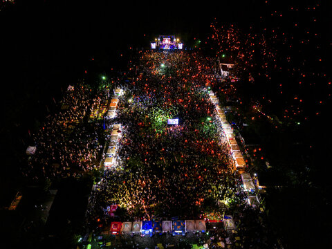 Aerial view of a vast crowd illuminated by countless lanterns creates a river of light at Parangtritis Lantern Festival, Yogyakarta, Special Region of Yogyakarta, Indonesia.