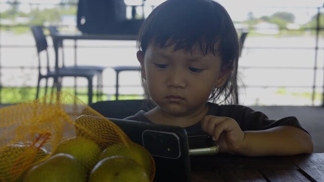 Toddler Is Sitting Watching Kids Songs On Mobile Phone, A relatable video of a toddler captivated by kids songs on mobile phone, creative storytelling and lifestyle documentary.