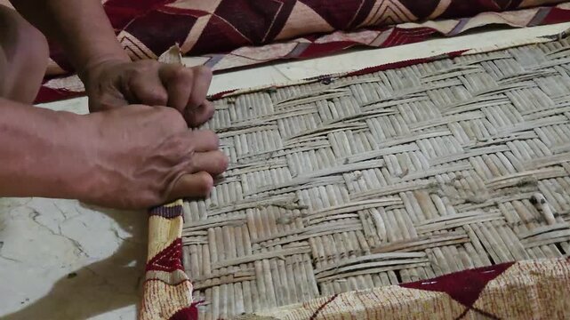 Close up of an upholsterer using a staple gun to attach fabric to a furniture frame