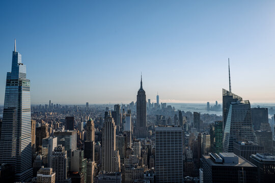 Aerial view of the majestic Empire State Building and other skyscrapers pierce the horizon under a serene blue sky, New York, New York, United States.